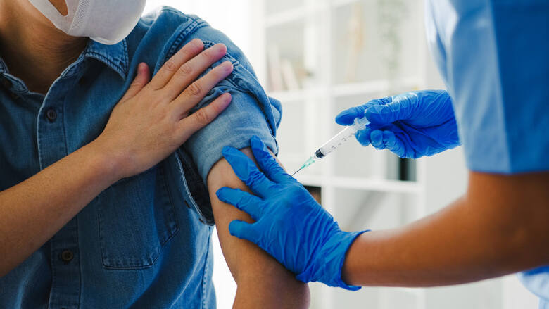 Pielęgniarka podająca szczepionkę przeciwko covid-19 starszemu pacjentowi
