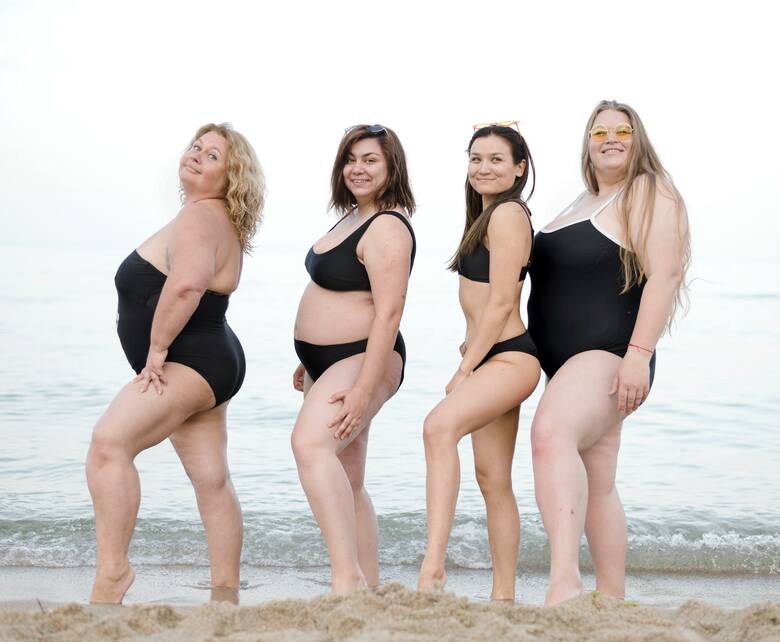 Kobiety stoją w rzędzie w strojach kąpielowych nad morzem