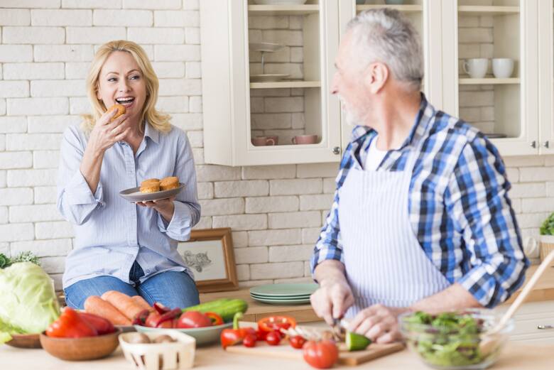 Para ludzi w średnim wieku przygotowuje warzywa w kuchni