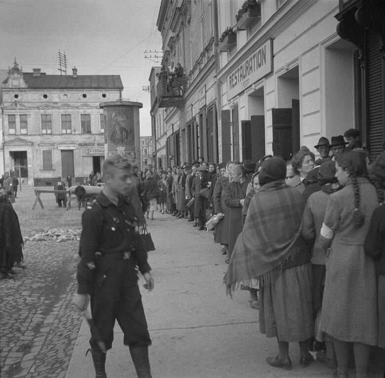 Rynek w Oświęcimiu ok. 1940 r. Na zdjęciu widać żydowskich oświęcimian i oświęcimianki z charakterystycznymi opaskami z gwiazda Dawida, które musiały