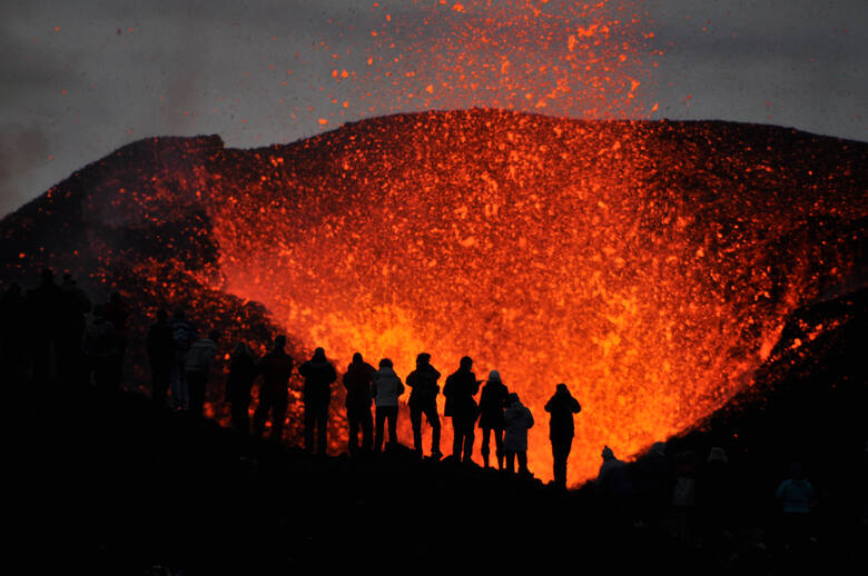 Grupa ludzi obserwująca erupcję wulkanu Eyjafjallajökull, Islandia
