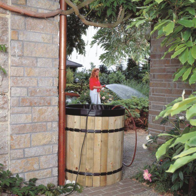 Zbiornik na wodę deszczową wykonany z drewnianych listewek i wyłożony folią to estetyczne i praktyczne rozwiązanie.