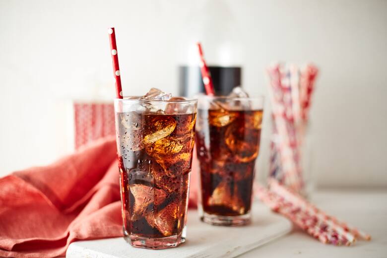 Napój cola w szklankach z lodem i słomkami