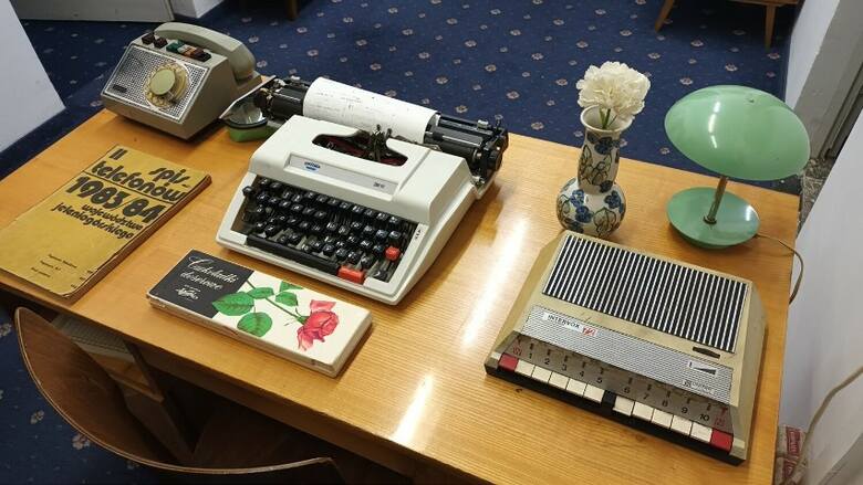 Maszyna do pisania, telefon z tarczą, wazon z kwiatkami i lampka. Tak wyglądało biurko każdej sekretarki jeszcze kilkadziesiąt lat temu >&