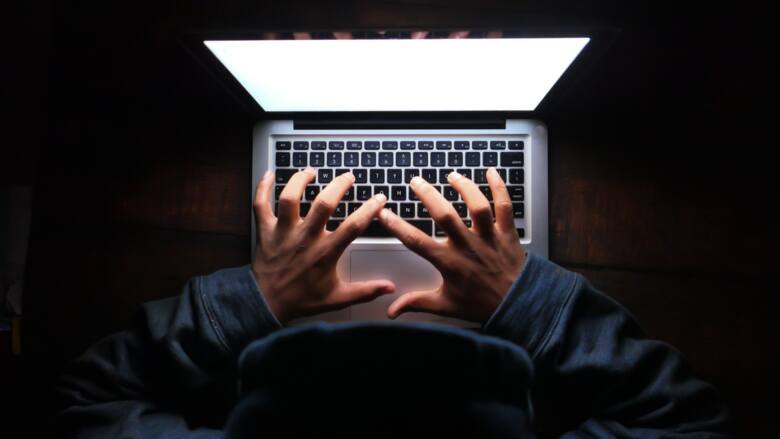 Haker pracujący przy laptopie