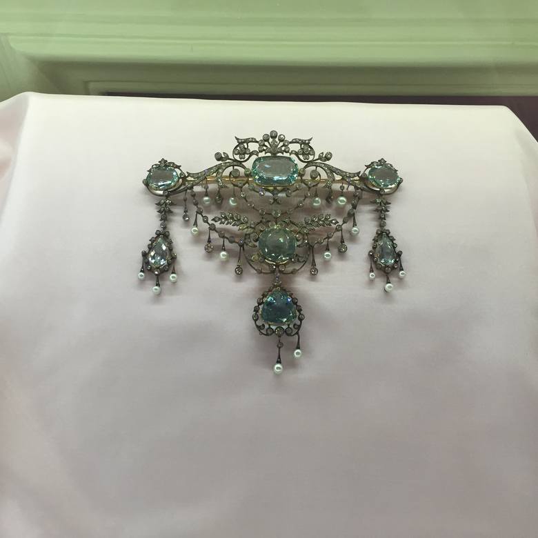 Devant de corsage (brosza-wisior) akwamarynowy z oprawą z gałązek brylantowych z perłami. Brosza ta była najdroższą w kolekcji broszek, które księżna posiadał w 1936 roku. Wyceniono ją wówczas ją na 2 200 marek. „Brosza ta jest kameryzowana  siedmioma akwamarynami barwy niebieskiej w złotej...