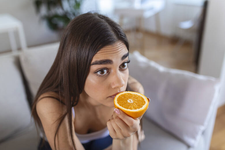 Kobieta wąchająca pomarańcz