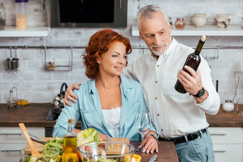 Para w średnim wieku ogląda butelkę wina