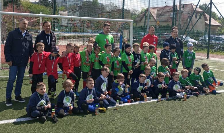 Pamiątkowe zdjęcie zawodników rywalizujących w kategorii U-8 w Kielcach - między innymi zespół Szkoły Podstawowej 25 i Szkoły Podstawowej 9 z trenerem