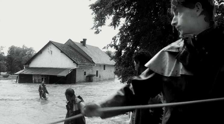 Opawica. 7 lipca 1997. Opawica po stronie polskiej i Opawice po czeskiej. Mala rzeczka zmieniła swój bieg i kilka domów we wsi po obu stronach zostało odciętych od drogi. Na zdjęciu strażacy próbują dostać się przez silny nurt do jednego z domów.