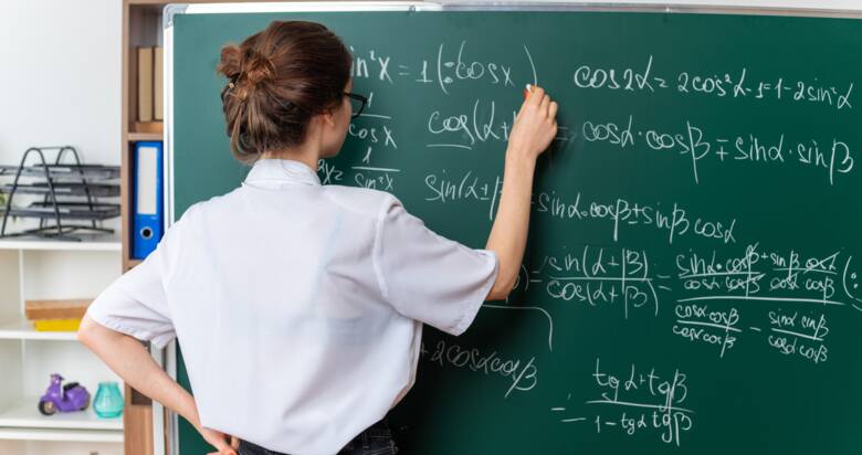 nauczycielka matematyki pisze coś na tablicy