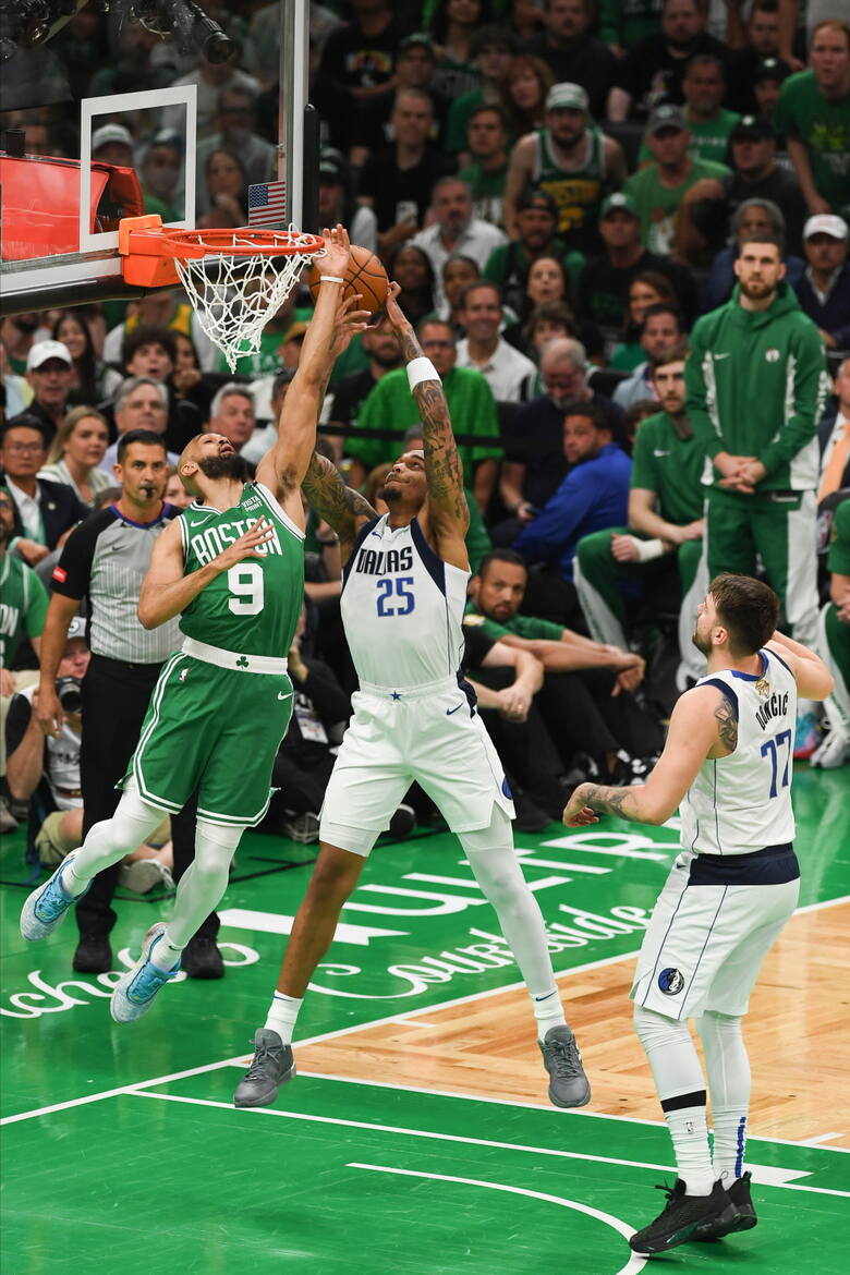Atakujący Dallas Mavericks P.J. Washington (w środku) walczy pod koszem z obrońcą Boston Celtics Derrickiem Whitem. Przygląda im się  gwiazdor Dallas