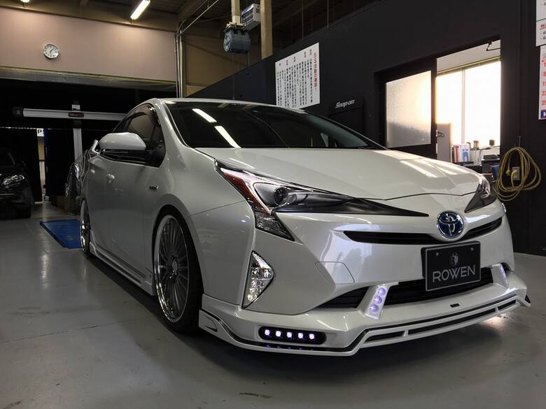 Toyota Prius Czarne wieloramienne felgi kontrastują z białą karoserią, a wzrok przyciągaj również nakładek na progi oraz świateł LED. Nie podano informacji
