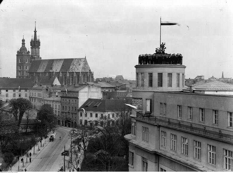 Widok z Pałacu Prasy. Na pierwszym planie z prawej budynek Poczty Głównej z orkiestrą pocztową na tarasie na dachu, dalej ulica Sienna i kościół Mariacki. Maj 1932 r.