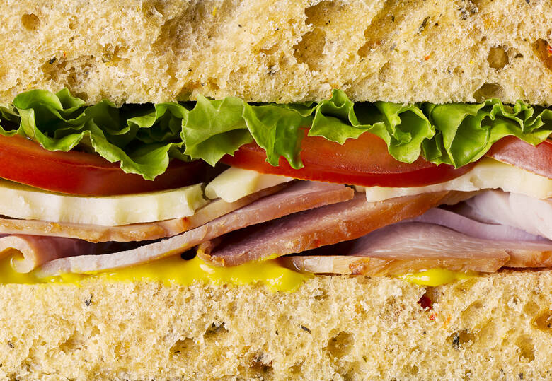 Przekrój przez sandwich z serem, szynką i warzywami w powiększeniu
