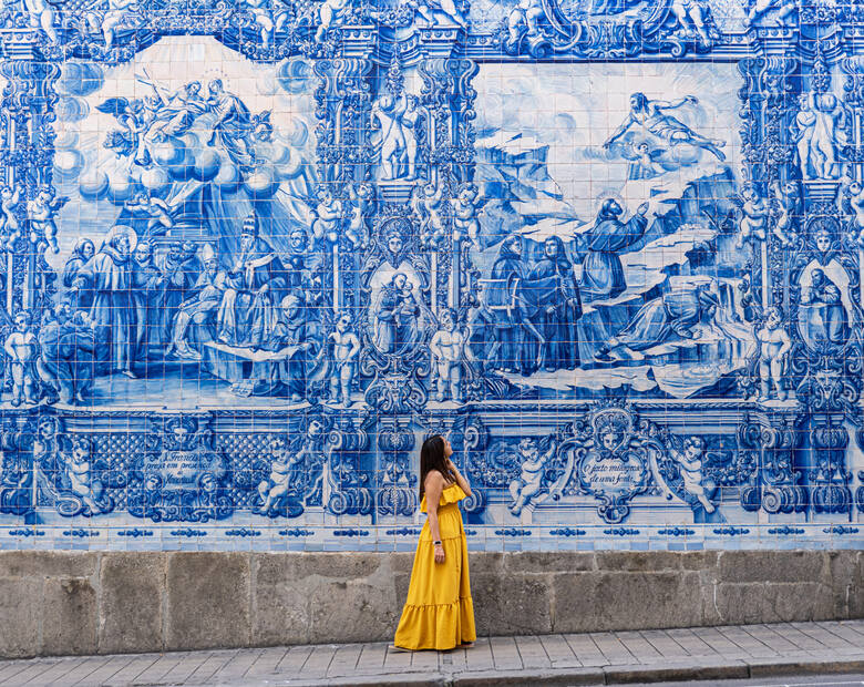 Kobieta w żółtej sukience na tle portugalskich kafelek