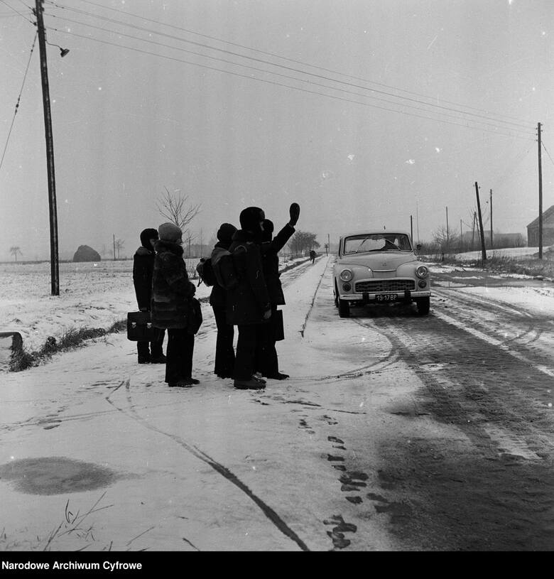 Zdjęcie datowane na okres 1976 - 1977Uczniowie gminnej szkoły w Płowcach próbują zatrzymać samochód Warszawa. Ciekawe, czy udało się im wrócić do domu