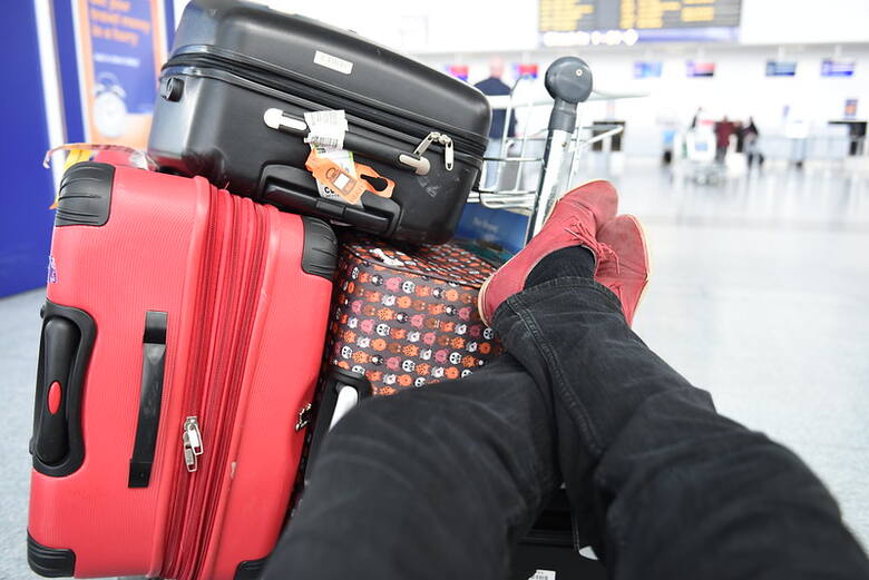 Podróżny z trzema walizkami na lotnisku