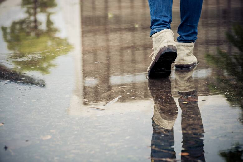 męskie buty w kałuży deszczu