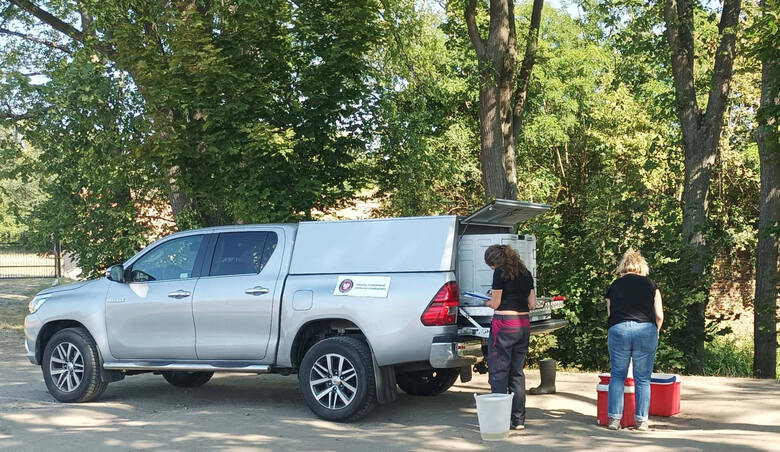 Pracownice Inspektoratu Ochrony Środowiska pobierają próbki wody z Odry na wysokości Twierdzy Kostrzyn.