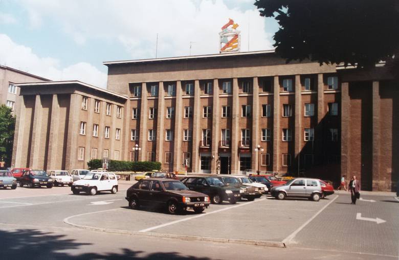 Urząd Miejski w Sosnowcu wyglądał wówczas nieco inaczej. Dopiero później dobudowano tzw. akwarium przed wejściem do budynku i dodatkowe piętro na górze. W latach dziewięćdziesiątych nad budynkiem dominował też duży herb Sosnowca. Uwagę zwraca również parking z tamtego czasu, na którym dominują...