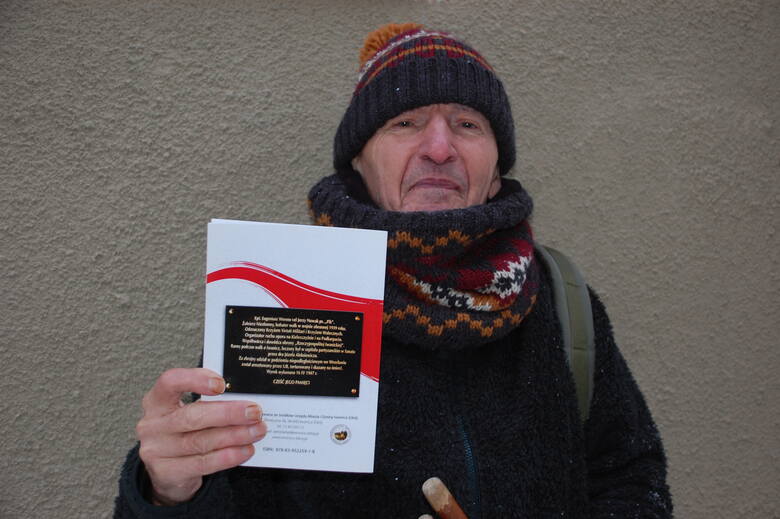 Janusz Bogdan Roszkowski prezentuje broszurę o kpt. Eugeniuszu Werensie "Piku". Na jej okładce jest zdjęcie tablicy poświęconej oficerowi