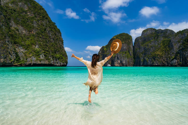 Radosna kobieta biegnąca po plaży na wyspie Phuket (Tajlandia)