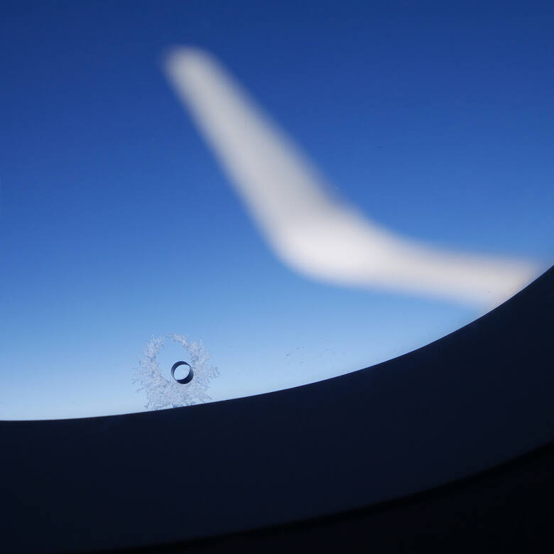 Zbliżenie na otwór w oknie samolotu