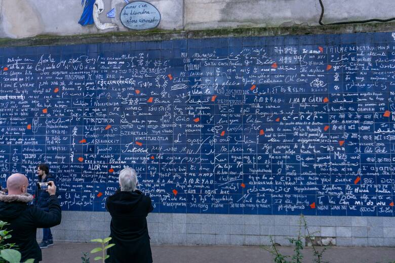 Turyści przed Murem Miłości w Paryżu