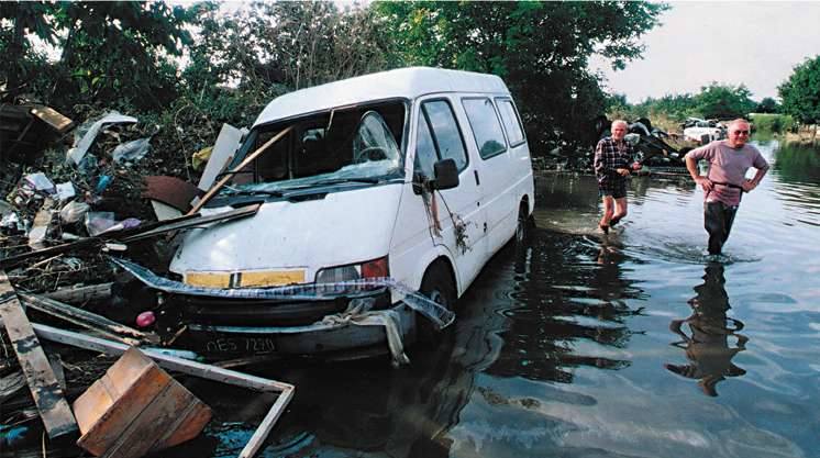 Opole 1997. Ulica Koszyka. Trzeci tydzień powodzi. Ogrodzenie ogródków działkowych jak sito wyłapało wszystko, co niosła ze sobą woda.