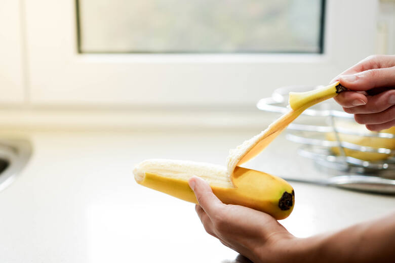 Osoba obiera banana ze skórki