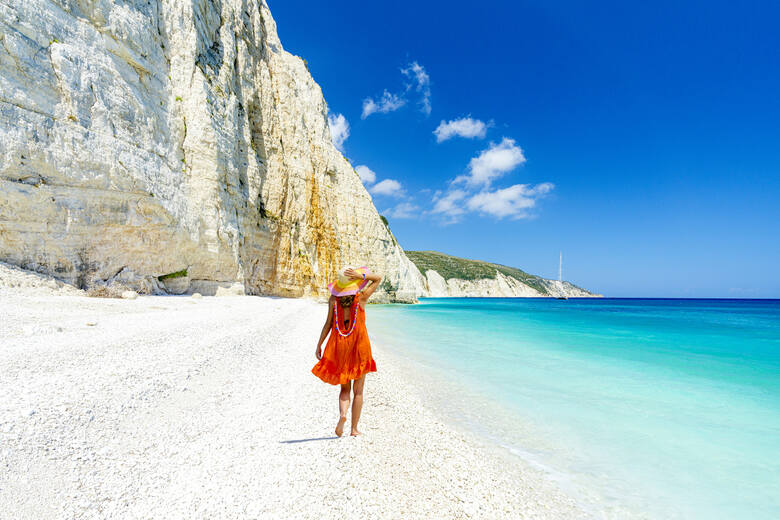 Kobieta spacerująca po malowniczej plaży Fteri na wyspie Kefalonia