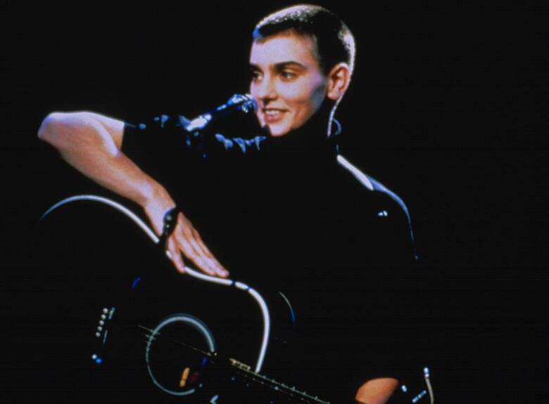 Sinéad O[/apos/]Connor na scenie, na kolanach trzyma gitarę