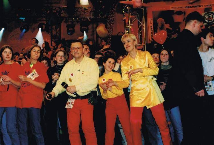 Już pierwsze finały Wielkiej Orkiestry Świątecznej Pomocy wygenerowały tradycję, która trwa do dziś. Czerwone spodnie, żółta koszula i czerwone okulary Jurka Owsiaka to prawie jak mundurek jednej niedzieli w roku.<br /> <br /> Na zdjęciu jeden z pierwszych finałów WOŚP. Jurek Owsiak i Agata...