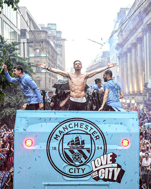 Jack Grealish z kolegami z Manchesteru City celebruje w autokarze na paradzie miejskiej zdobycie potrójnej korony