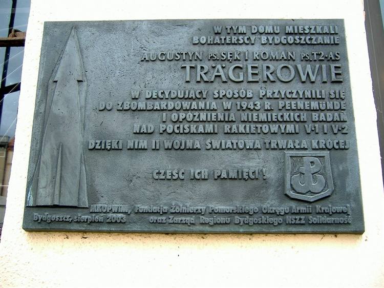 W sierpniu 2003 r. na ścianie domu przy Wełnianym Rynku 10 odsłonięto tablicę upamiętniającą Augustyna i Romana TrägerówAugustyn Träger, ps. „Sęk”, „Tragarz”