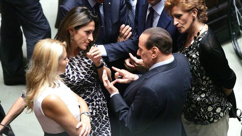 Premier Silvio Berlusconi w otoczeniu deputowanych we włoskim parlamencie