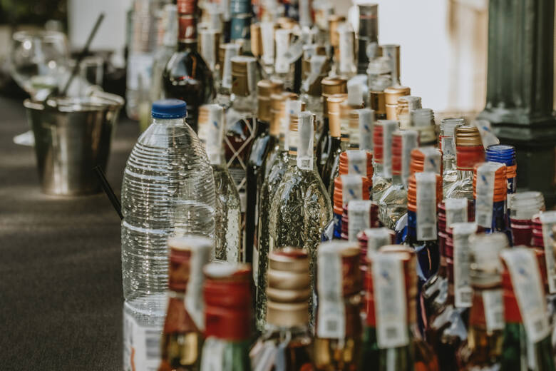 Butelki różnych rodzajów alkoholi ustawione w rzędzie na stole