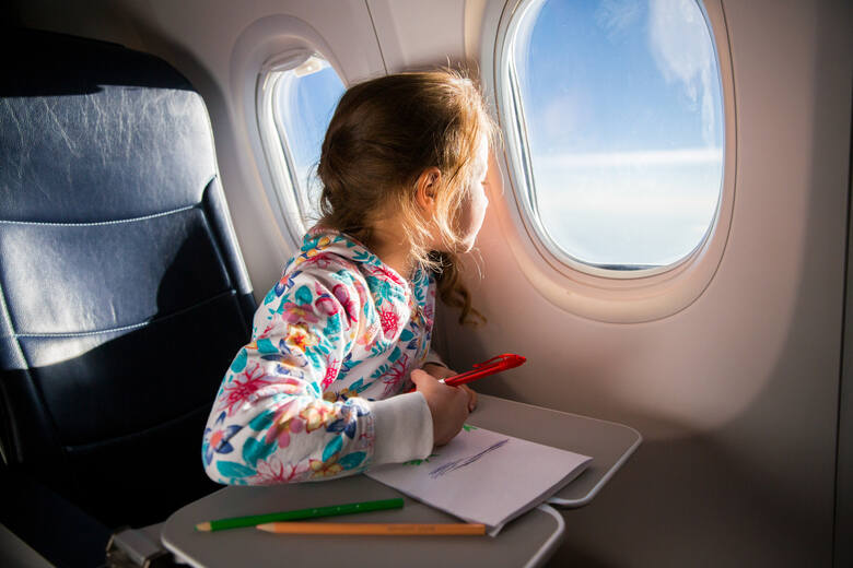Dziewczynka wyglądająca przez okno samolotu