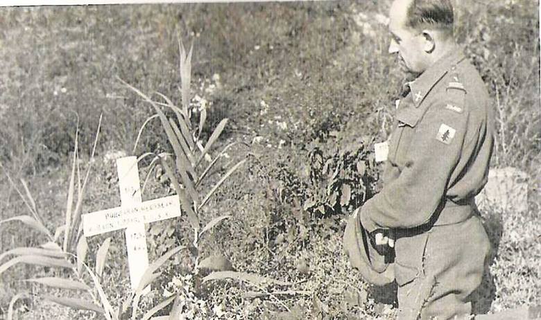 Po bitwie o Monte Cassino ksiądz Joniec modli się nad grobem jednego z poległych oficerów