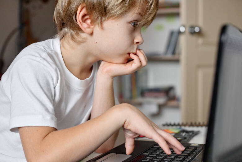 Dziecko siedzi przed komputerem