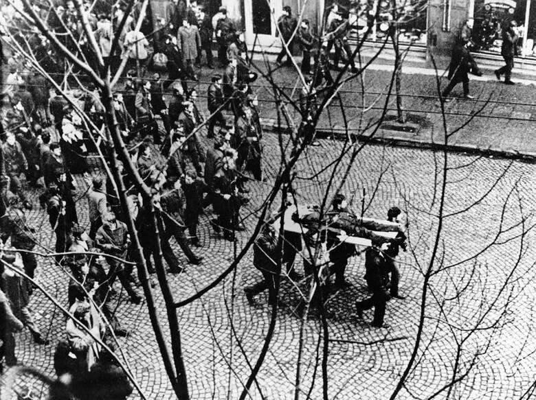 17 grudnia 1970. Robotnicy niosą na drzwiach ciało Zbyszka Godlewskiego.