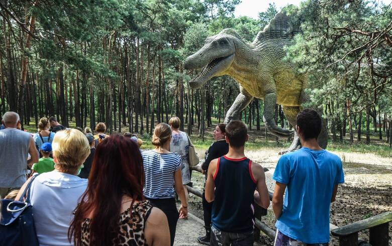 Turyści zwiedzający dinopark