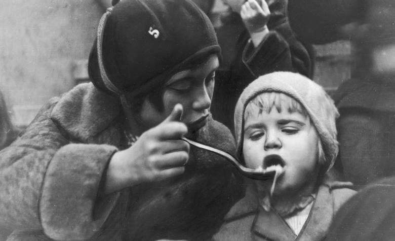 Dzieci bezrobotnych podczas posiłku wydawanego przez organizację charytatywną w Katowicach (1931).