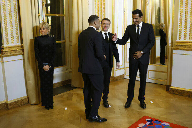 Kylian Mbappe wita się z emirem Kataru Tamimem bin Hamadem Al Thanim w obecności prezydenta Fracnji Emmanuela Macrona