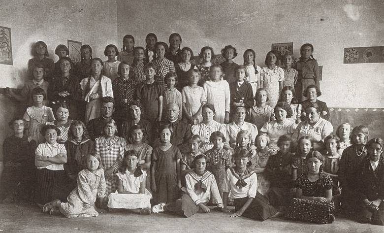 W szkole w Podhajcach. Maria Wojciechowska siedzi obok księdza, z lewej strony
