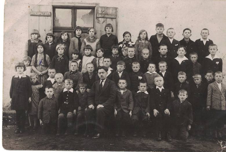 Jednoklasowa szkoła powszechna, z czterema oddziałami, w Strzelewie, rok 1931. - Siedzę drugi z lewej od nauczyciela Alojzego Wesołowskiego, w bluzie z białym kołnierzykiem. Na zdjęciu jest też moja siostra Marta  (dziewczynka z warkoczami).