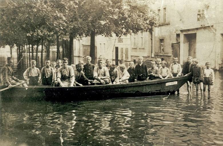 Na zdjęciu grupa osób stojąca w wodzie oraz siedząca na łodzi, łódź ta należała do pana Augusta Wolfa, stolarza mieszkającego kiedyś prawdopodobnie przy Roßstraße 93 (Marksa). Fotografia pochodzi z 1930 roku.