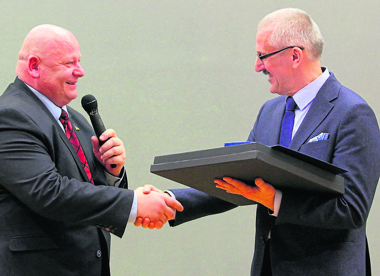 Jerzy Miller (z prawej) odbiera pamiątkowy upominek z rąk prezesa Polskiego Związku Taekwodno Olimpijskiego.