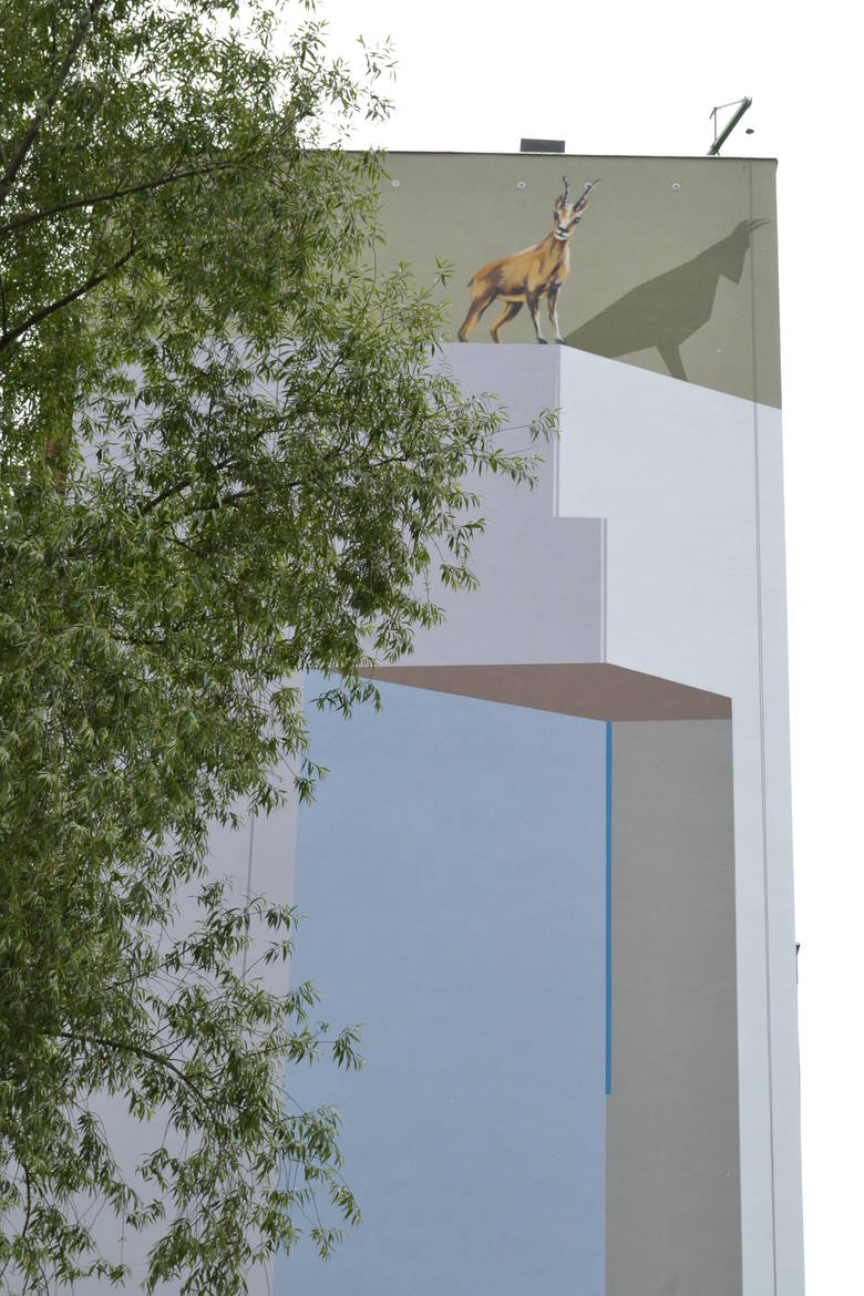 Ze ściany 10-piętrowego bloku na osiedlu Karpackim spogląda kozica stojąca nad  oblodzonym urwiskiem skalnym. Tatrzańska kozica spoziera ze szczytu wysokiej ściany także na ruchliwą aleję Andersa.  <br /> <br /> Projekt powstał w nawiązaniu do szczytu Mnich w Tatrach, kt&oacute;ry znajduje się...